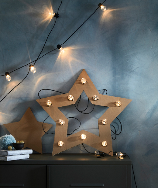 Картонена звезда в лампички върху нея, поставена на шкаф