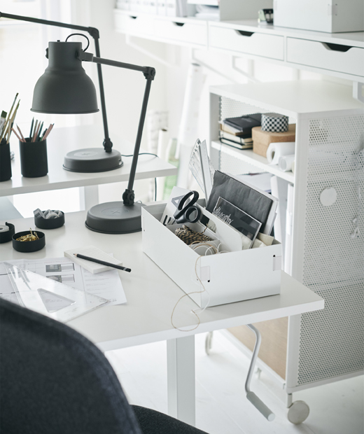 Тъмносива работна лампа IKEA HEKTAR и органайзер KVISSLE на бяло бюро. Бяло бюро с тъмносива настолна лампа.