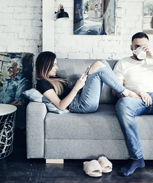 Катарзина и Миколай си почиват на техния сив диван IKEA GRÄLVIKEN. Катарзина и Миколай си почиват на техния сив диван пред боядисана в бяло тухлена стена.